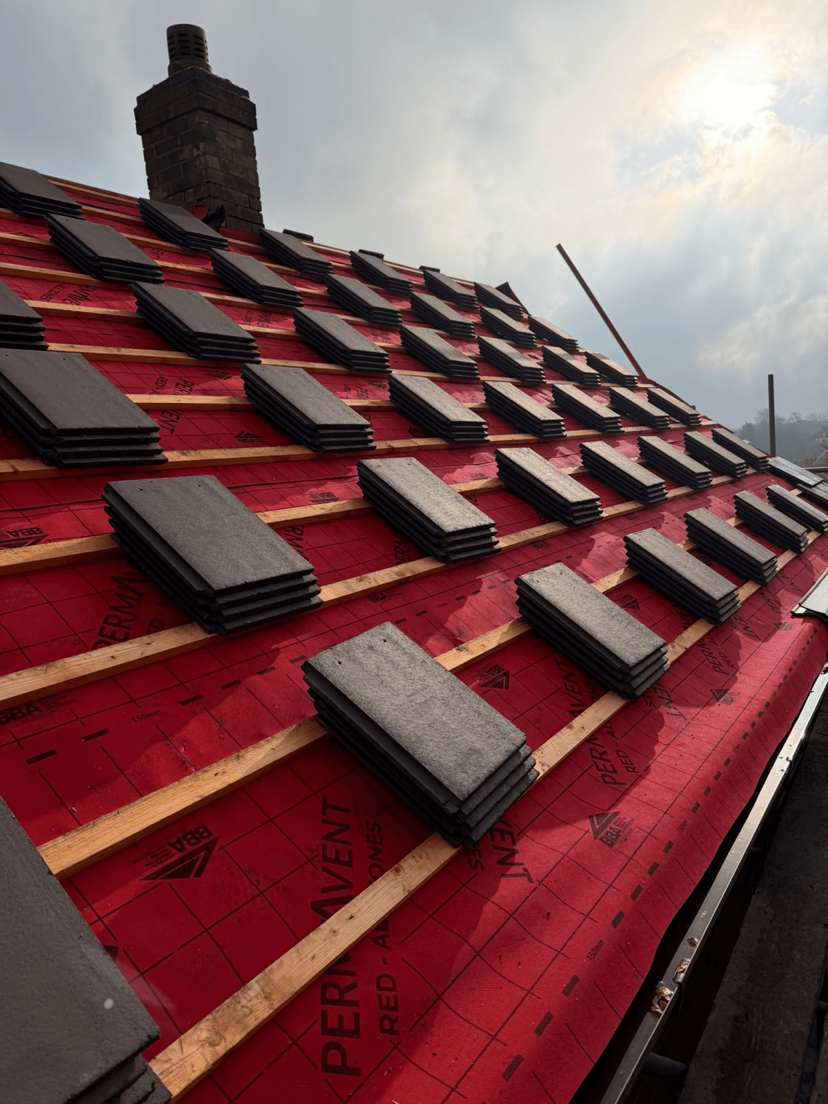 Roof tiles being laid on breathable membrane